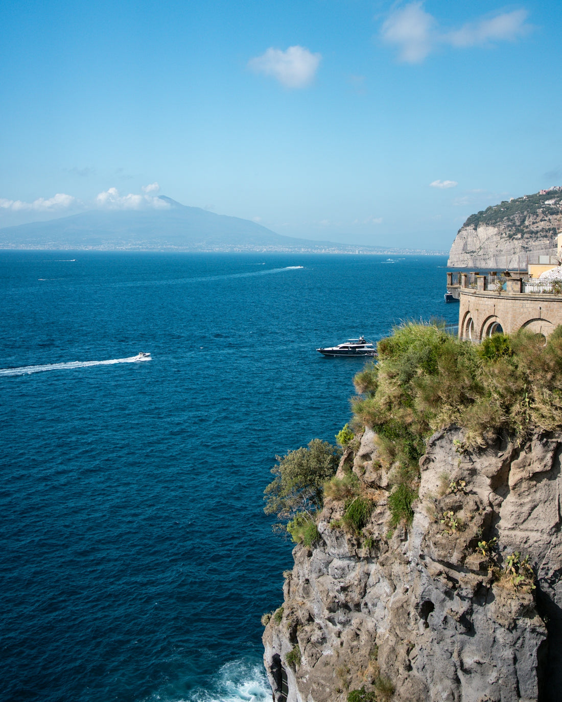 Cliffside views of the ocean with a mountain.