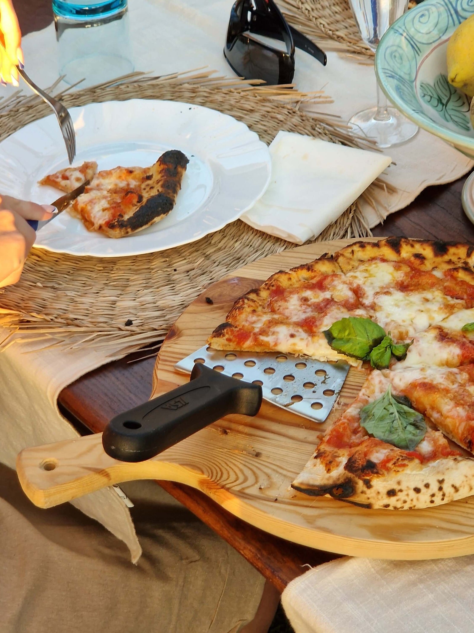 Delicious pizza served during a private pizza making class with sea view, featuring fresh basil on top.