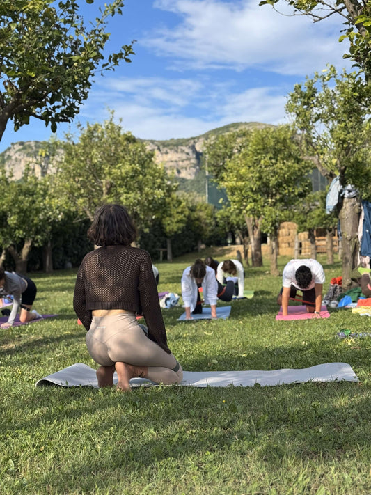 Participants in Sorrento Pilates Class practicing outdoors in a lemon grove with scenic hills in the background.