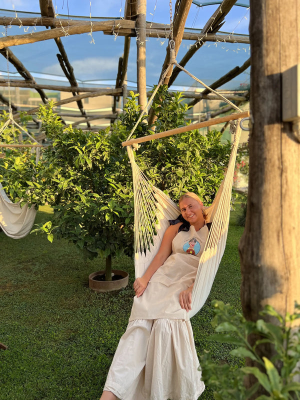Woman relaxing in a hammock surrounded by lemon trees in a serene setting during the private pizza making class..